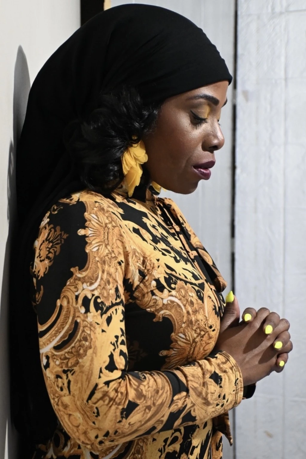 YaYa Israel in profile, wearing black and gold